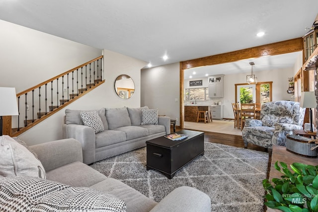 living area with wood finished floors, recessed lighting, and stairs