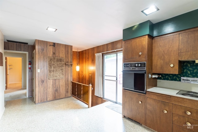 904 Lewis St, Moscow, ID 83843 - kitchen with oven, wood walls, stainless steel electric stovetop, brown cabinets, and light countertops