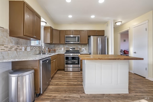 kitchen featuring wood counters, stainless steel appliances, dark hardwood / wood-style flooring, and sink