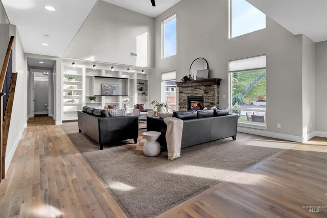 2043 E Lodge Trail Dr, Meridian, ID 83642 - living area with wood finished floors, a stone fireplace, baseboards, a towering ceiling, and recessed lighting