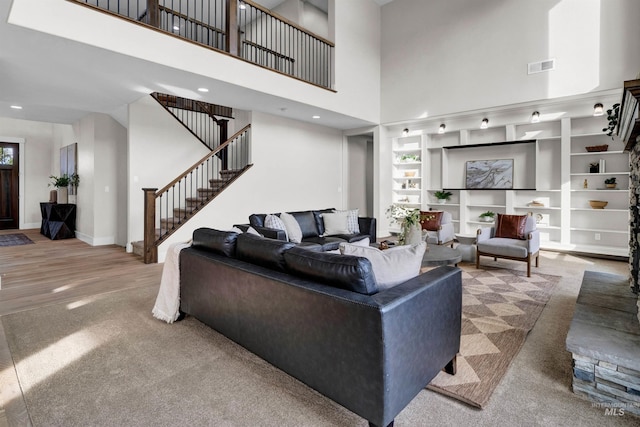 2043 E Lodge Trail Dr, Meridian, ID 83642 - carpeted living room featuring stairs, a towering ceiling, built in shelves, baseboards, and recessed lighting