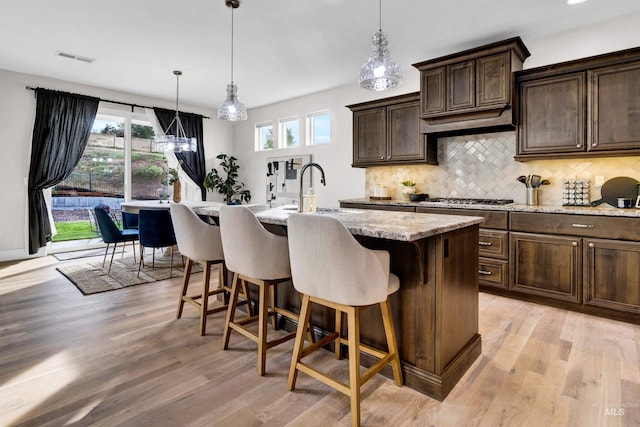 2043 E Lodge Trail Dr, Meridian, ID 83642 - kitchen featuring a sink, light wood-style floors, tasteful backsplash, and a kitchen island with sink
