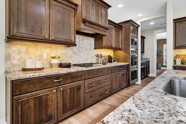2043 E Lodge Trail Dr, Meridian, ID 83642 - kitchen featuring stainless steel appliances, light stone counters, decorative backsplash, light wood-style floors, and dark brown cabinetry
