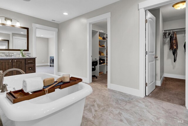 2043 E Lodge Trail Dr, Meridian, ID 83642 - bathroom featuring a walk in closet, a freestanding bath, vanity, recessed lighting, and baseboards