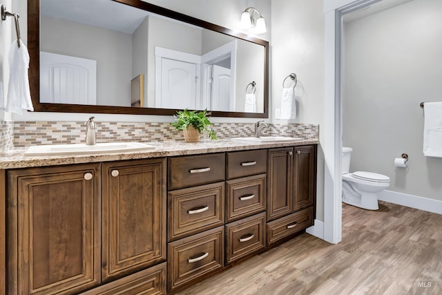 2043 E Lodge Trail Dr, Meridian, ID 83642 - full bath featuring decorative backsplash, toilet, wood finished floors, double vanity, and baseboards