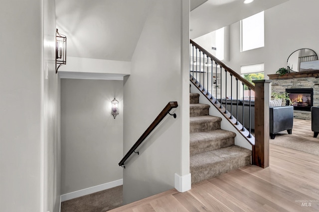 2043 E Lodge Trail Dr, Meridian, ID 83642 - stairway with baseboards, a stone fireplace, wood finished floors, and a towering ceiling