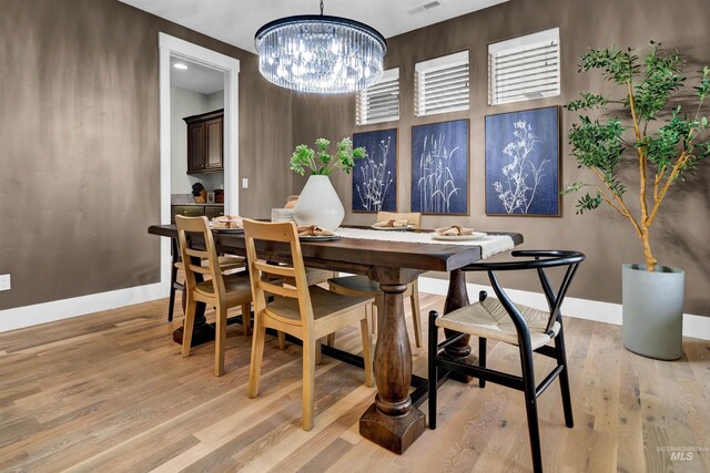 2043 E Lodge Trail Dr, Meridian, ID 83642 - dining room featuring a chandelier, baseboards, and light wood-style floors