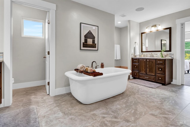 2043 E Lodge Trail Dr, Meridian, ID 83642 - full bath featuring marble finish flooring, vanity, a soaking tub, baseboards, and toilet