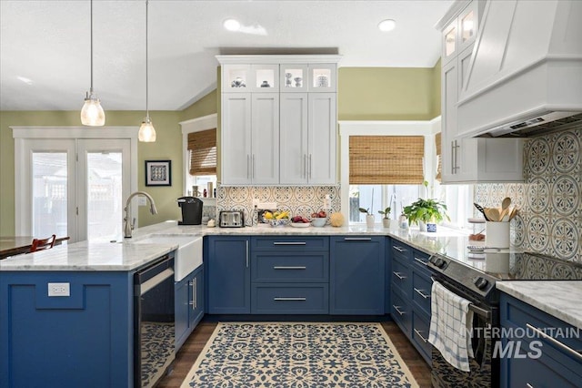 kitchen with a sink, a peninsula, black range with electric cooktop, blue cabinetry, and custom range hood