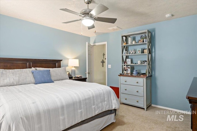 bedroom with ceiling fan, a textured ceiling, light carpet, and visible vents