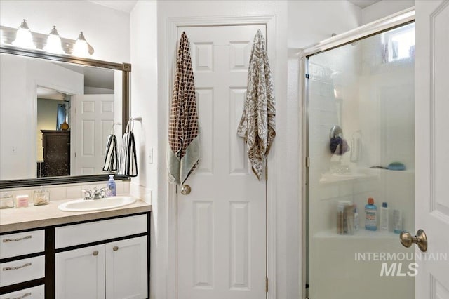bathroom featuring a shower stall and vanity