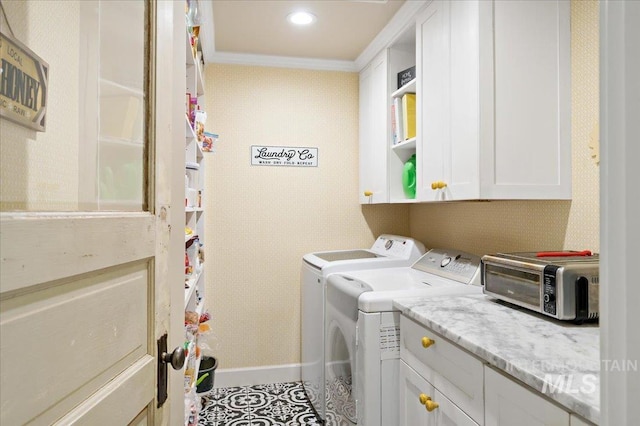 laundry room with a toaster, baseboards, separate washer and dryer, cabinet space, and ornamental molding