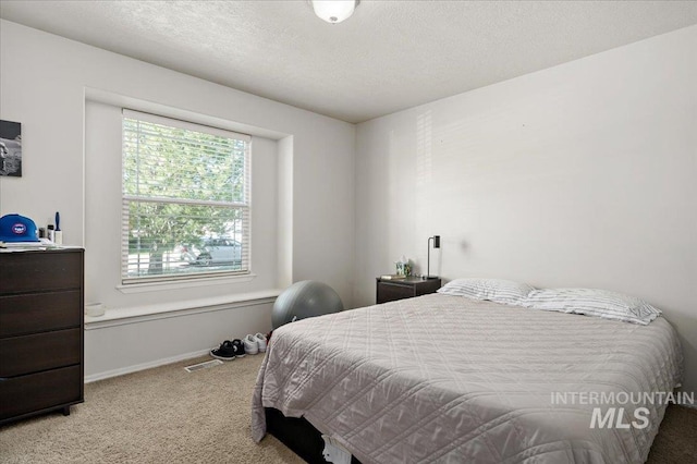 carpeted bedroom with a textured ceiling and baseboards