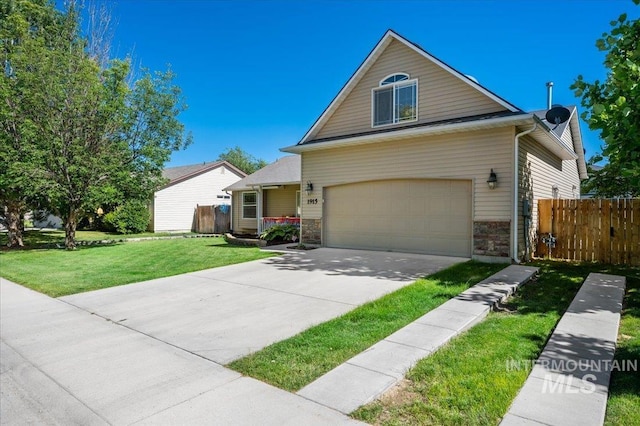 view of front facade with a front lawn, fence, driveway, and a garage