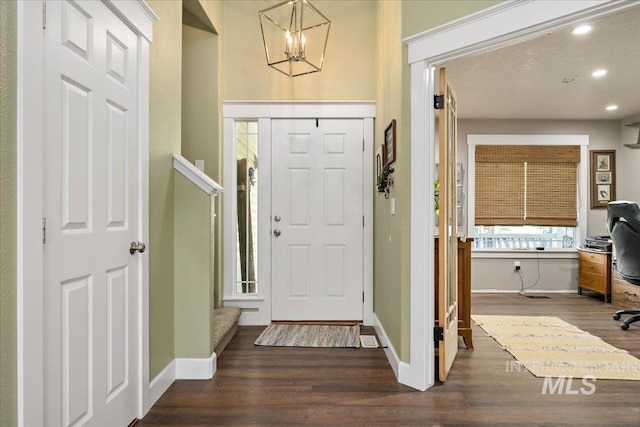 foyer with baseboards, wood finished floors, recessed lighting, and a notable chandelier