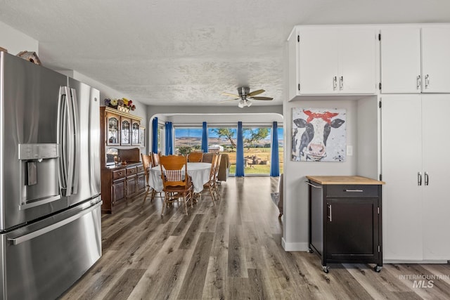 2208 Keithley Creek Rd, Midvale, ID 83645 - kitchen with stainless steel fridge, wood finished floors, white cabinets, a ceiling fan, and a textured ceiling