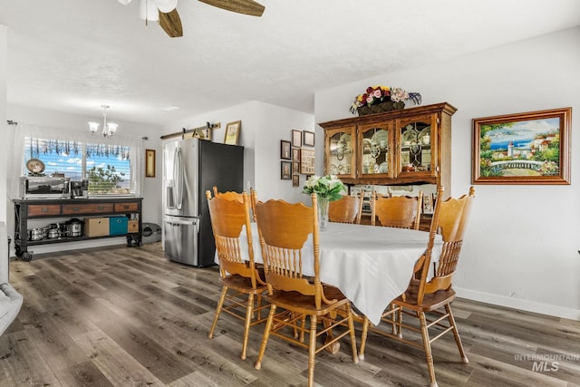 2208 Keithley Creek Rd, Midvale, ID 83645 - dining area with a barn door, wood finished floors, a chandelier, and ceiling fan