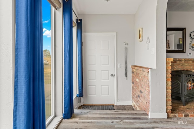 2208 Keithley Creek Rd, Midvale, ID 83645 - foyer with a wood stove, arched walkways, and wood finished floors