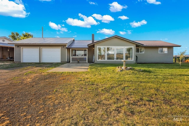 2208 Keithley Creek Rd, Midvale, ID 83645 - rear view of property featuring dirt driveway, a metal roof, an attached garage, and a lawn