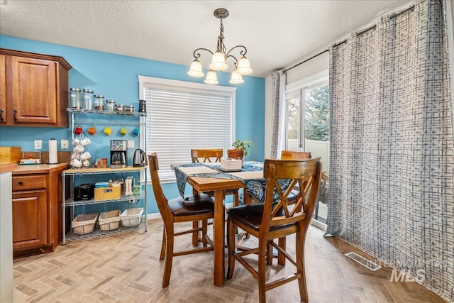 2030 W Cabot Ave, Nampa, ID 83686 - dining room featuring a chandelier, visible vents, a textured ceiling, and baseboards