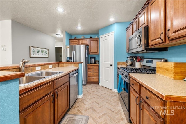 2030 W Cabot Ave, Nampa, ID 83686 - kitchen with a sink, a textured ceiling, appliances with stainless steel finishes, and brown cabinetry