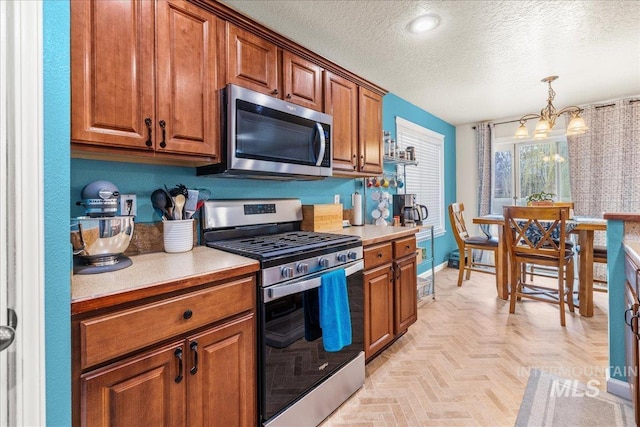 2030 W Cabot Ave, Nampa, ID 83686 - kitchen with brown cabinets, appliances with stainless steel finishes, light countertops, and an inviting chandelier
