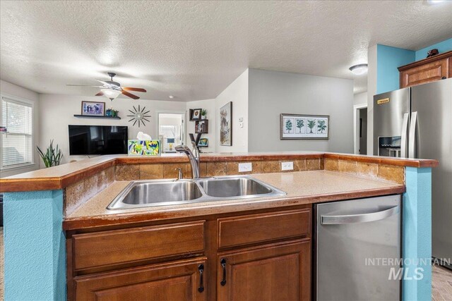 2030 W Cabot Ave, Nampa, ID 83686 - kitchen with brown cabinetry, ceiling fan, a sink, appliances with stainless steel finishes, and open floor plan