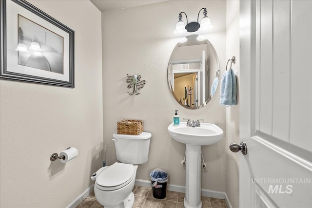 2030 W Cabot Ave, Nampa, ID 83686 - bathroom with a sink, baseboards, toilet, and tile patterned flooring