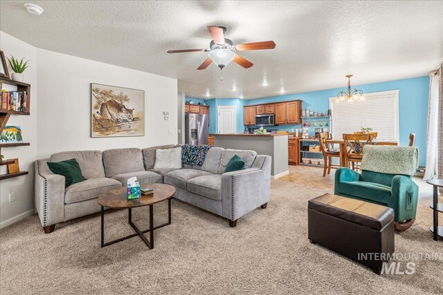 2030 W Cabot Ave, Nampa, ID 83686 - living area featuring baseboards, ceiling fan with notable chandelier, light colored carpet, and a textured ceiling