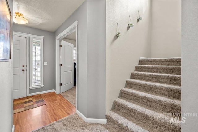 2030 W Cabot Ave, Nampa, ID 83686 - foyer entrance featuring stairs, wood finished floors, baseboards, and a textured ceiling