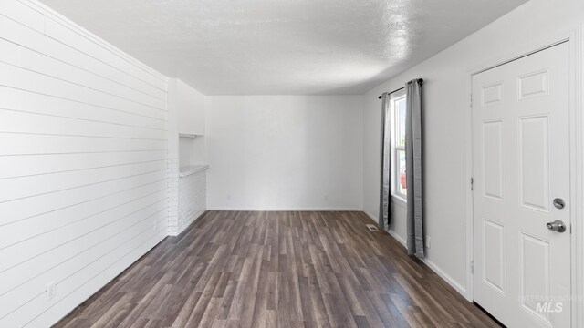 219 14th Ave N, Nampa, ID 83687 - empty room with dark wood-style flooring, baseboards, and a textured ceiling