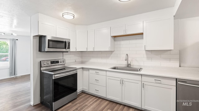 219 14th Ave N, Nampa, ID 83687 - kitchen with appliances with stainless steel finishes, a sink, light countertops, white cabinetry, and a textured ceiling