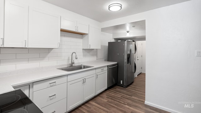 219 14th Ave N, Nampa, ID 83687 - kitchen featuring a sink, stainless steel appliances, baseboards, backsplash, and dark wood-style flooring