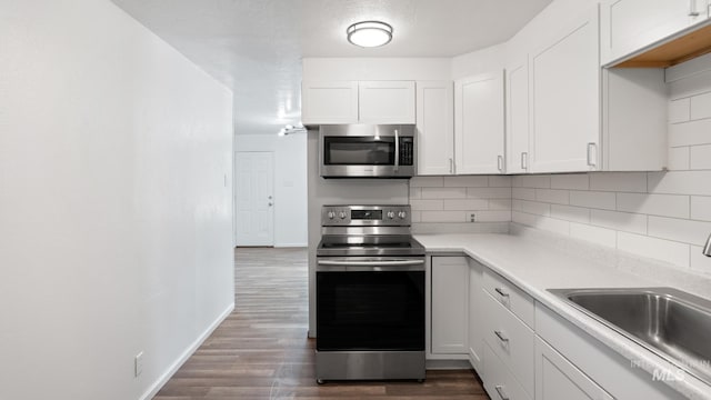 219 14th Ave N, Nampa, ID 83687 - kitchen featuring appliances with stainless steel finishes, a sink, dark wood-type flooring, backsplash, and baseboards