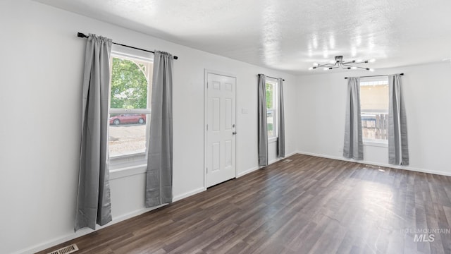 219 14th Ave N, Nampa, ID 83687 - foyer entrance with plenty of natural light, dark wood-style floors, a chandelier, baseboards, and a textured ceiling