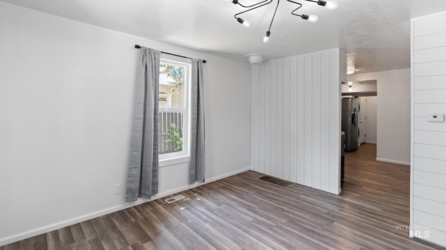 219 14th Ave N, Nampa, ID 83687 - spare room featuring wood finished floors, a chandelier, and baseboards