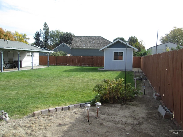 view of yard featuring an outdoor structure and a fenced backyard