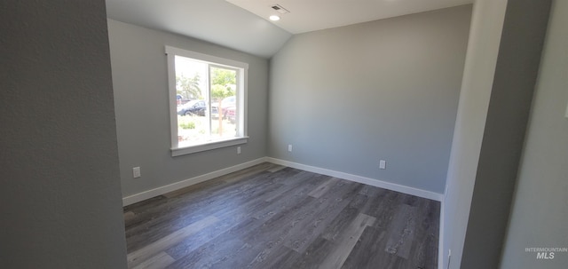 unfurnished room with vaulted ceiling and dark hardwood / wood-style flooring