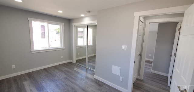 unfurnished bedroom featuring a closet and dark hardwood / wood-style floors