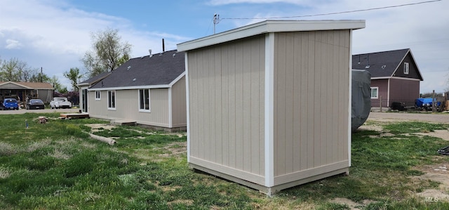 view of property exterior with a storage unit and a yard