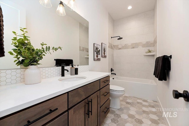 full bathroom featuring toilet, vanity, tiled shower / bath combo, and tasteful backsplash