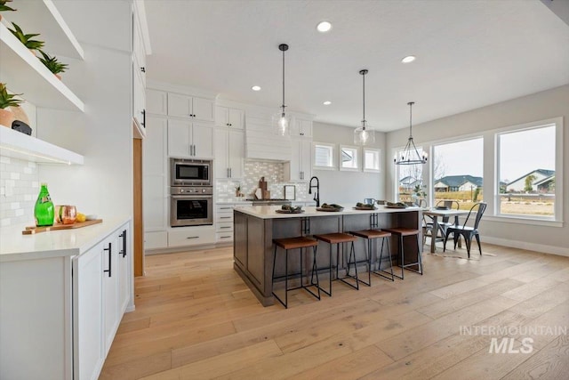 kitchen with stainless steel appliances, white cabinets, and tasteful backsplash