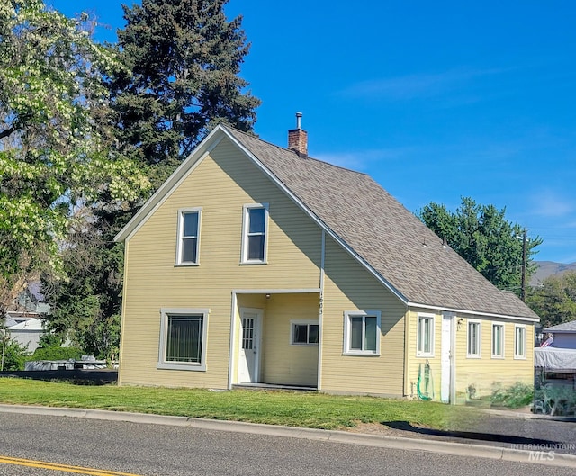 1603 11th Ave, Lewiston, ID 83501 - view of front facade featuring a chimney, a front lawn, and roof with shingles