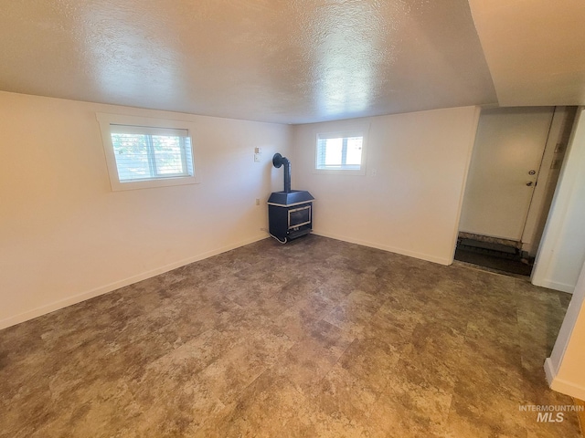 1603 11th Ave, Lewiston, ID 83501 - basement with a wood stove, a textured ceiling, and baseboards