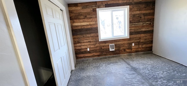 spare room featuring wood walls