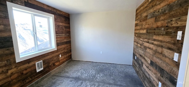 spare room featuring wood walls