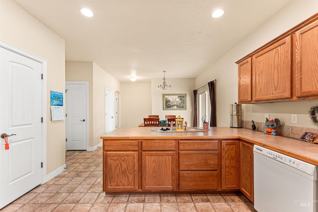 kitchen featuring white dishwasher, a peninsula, a chandelier, brown cabinetry, and recessed lighting
