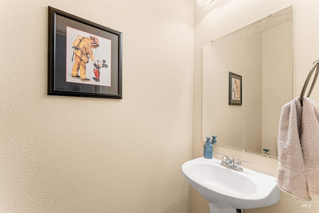 bathroom with a sink and a textured wall