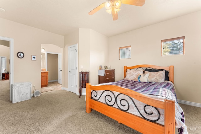 bedroom with light carpet, arched walkways, baseboards, and a ceiling fan