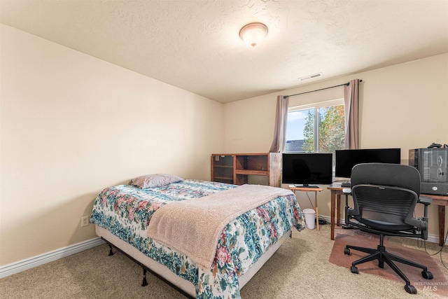 carpeted bedroom featuring baseboards and an office area